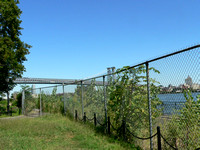 The chain link fence overgrown with weeds blocking the waterfront in 2008.